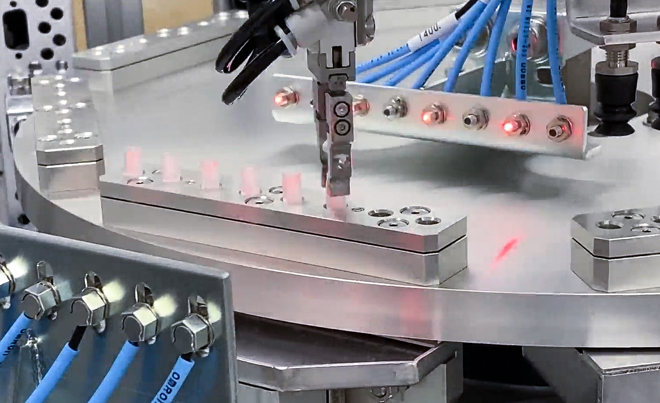 Automated robot arm assembling a POCT cartridge device